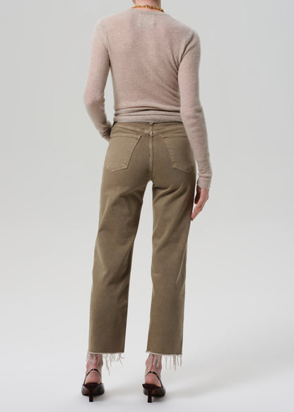 Person wearing a beige sweater and khaki pants on a white background