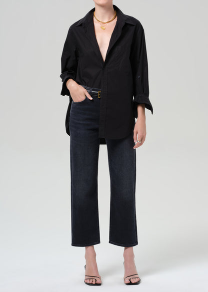 Person wearing a black shirt and black jeans on a grey background