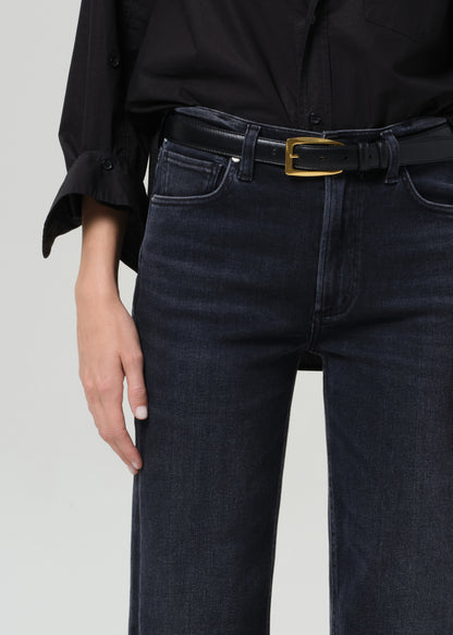 Person wearing a black shirt and black jeans on a grey background