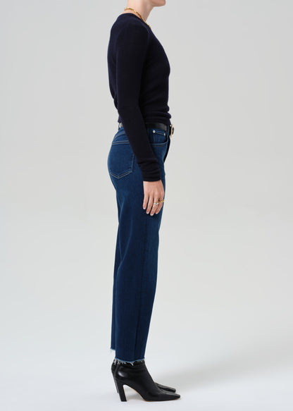 Person wearing a dark blue sweater and jeans on a white background