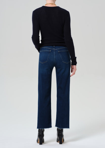 Person wearing dark blue jeans and a black sweater on a white background