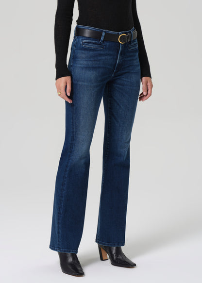 Person wearing blue jeans with a black belt on a white background