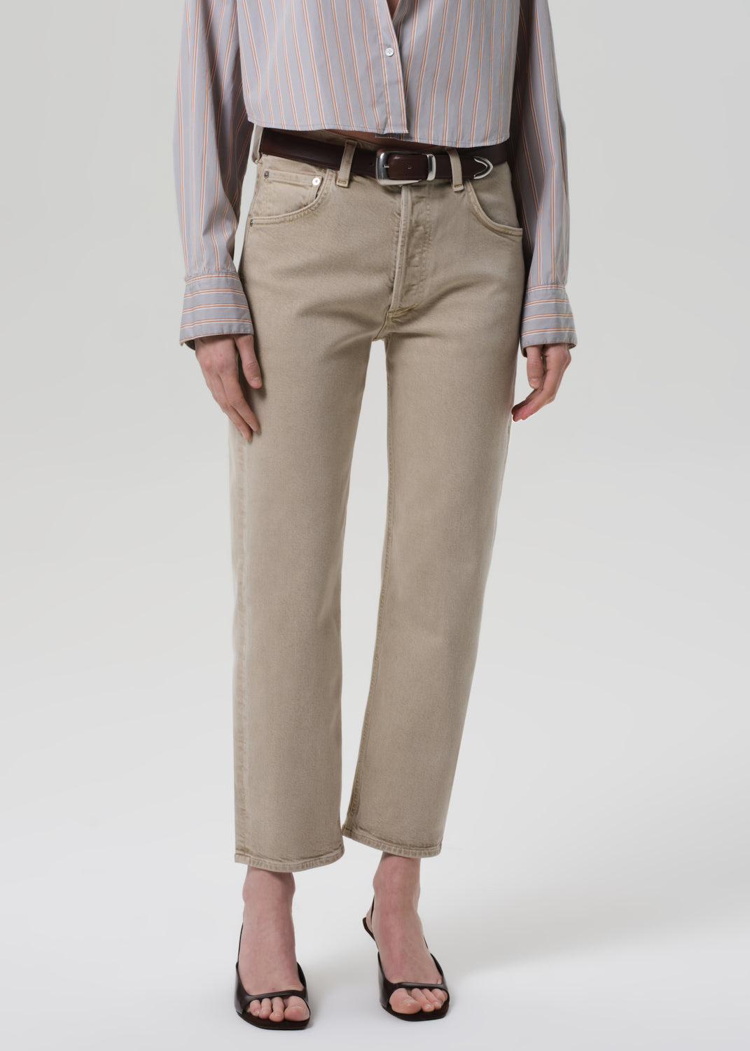 Person wearing beige pants and a striped shirt on a white background