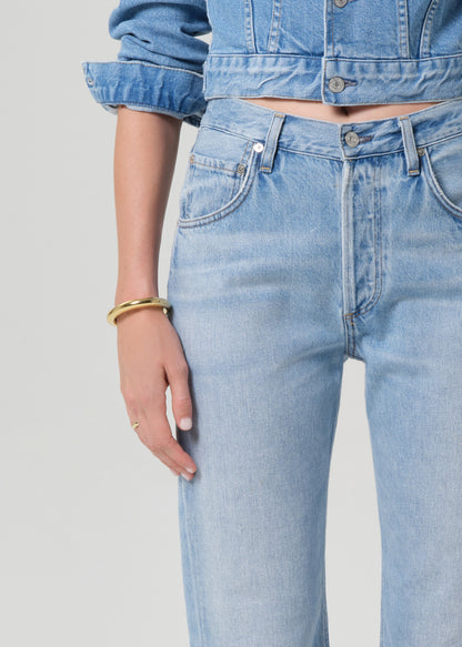 Light blue jeans worn by a person on a gray background