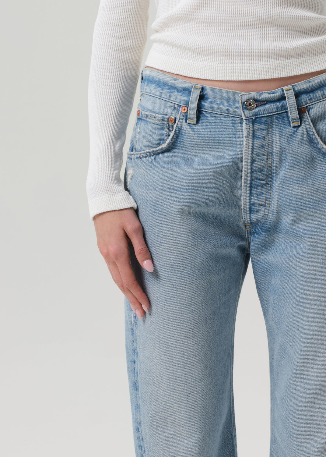 Light blue jeans worn by a person on a plain background