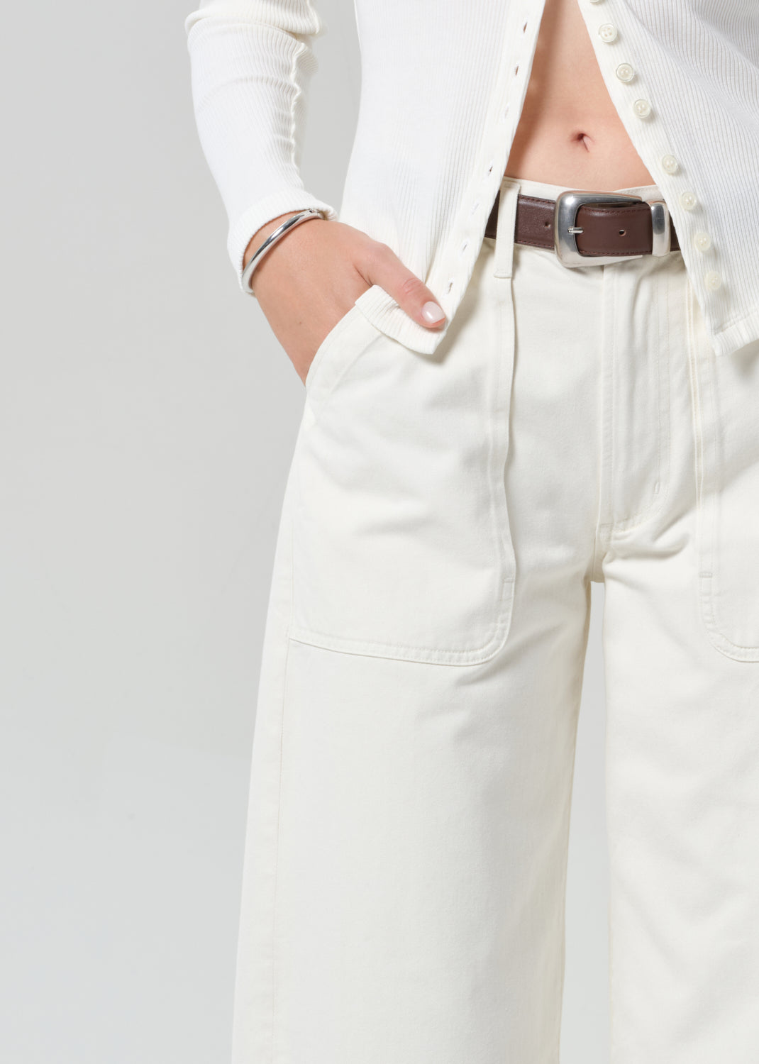 Person wearing white cardigan with off-white cargo pants