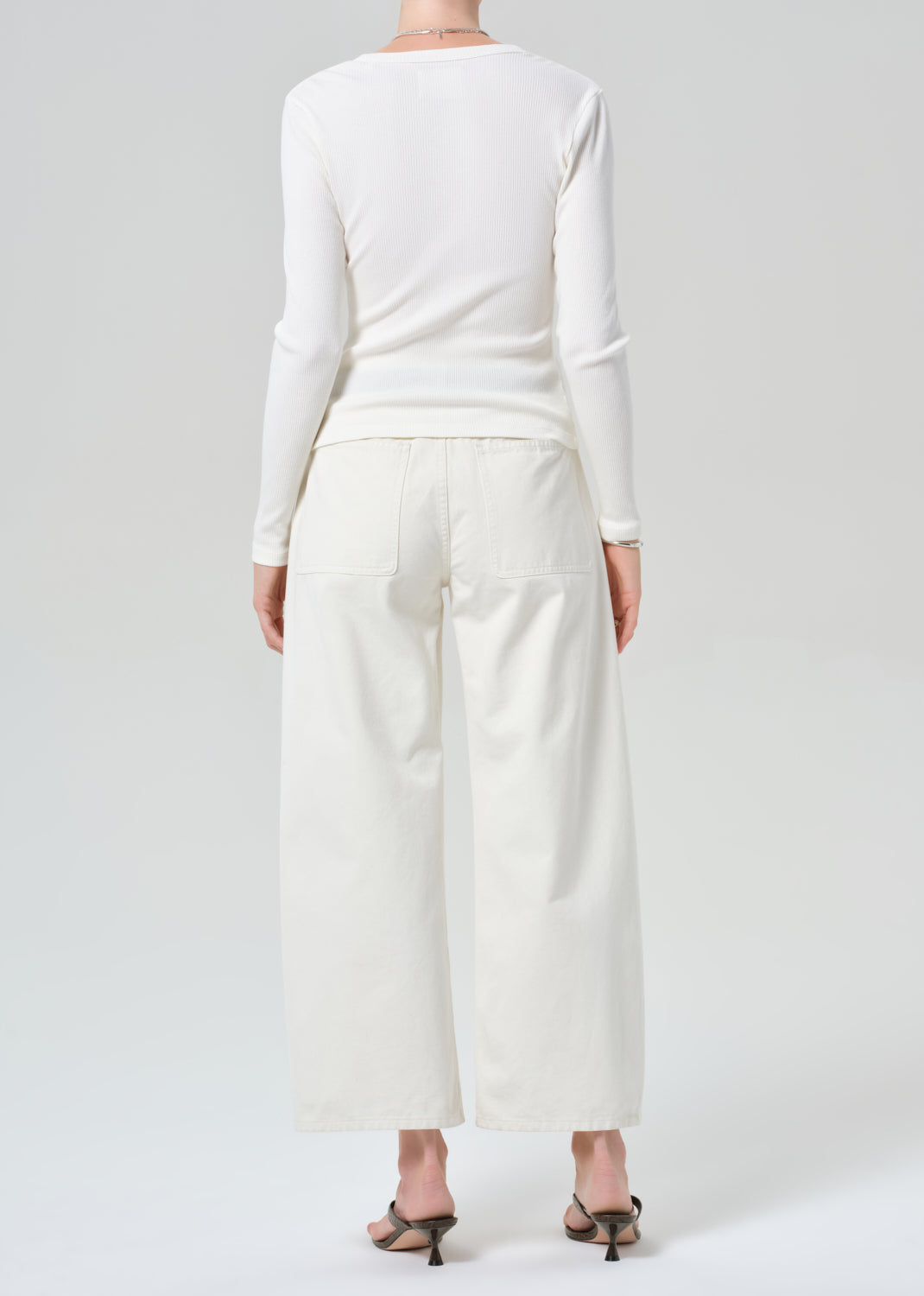 Person wearing white cardigan with off-white cargo pants