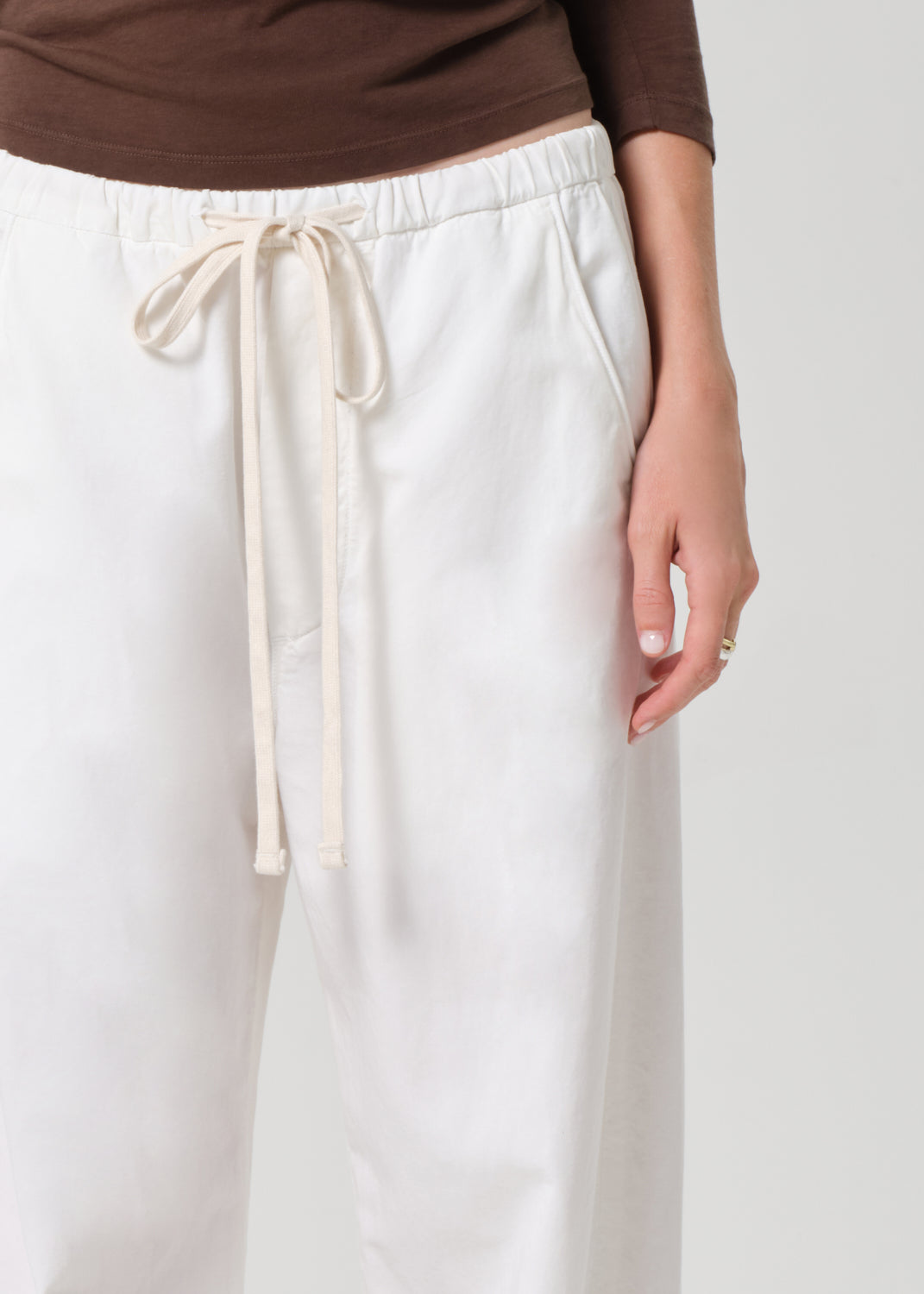 White pants with a drawstring on a plain background