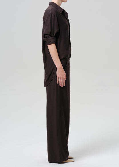 Person wearing a brown outfit on a grey background
