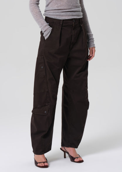 Person wearing dark brown cargo pants on a grey background