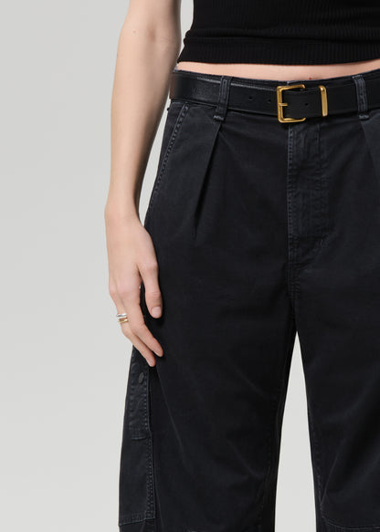 Person wearing a black tee and black cargo pants on a plain background