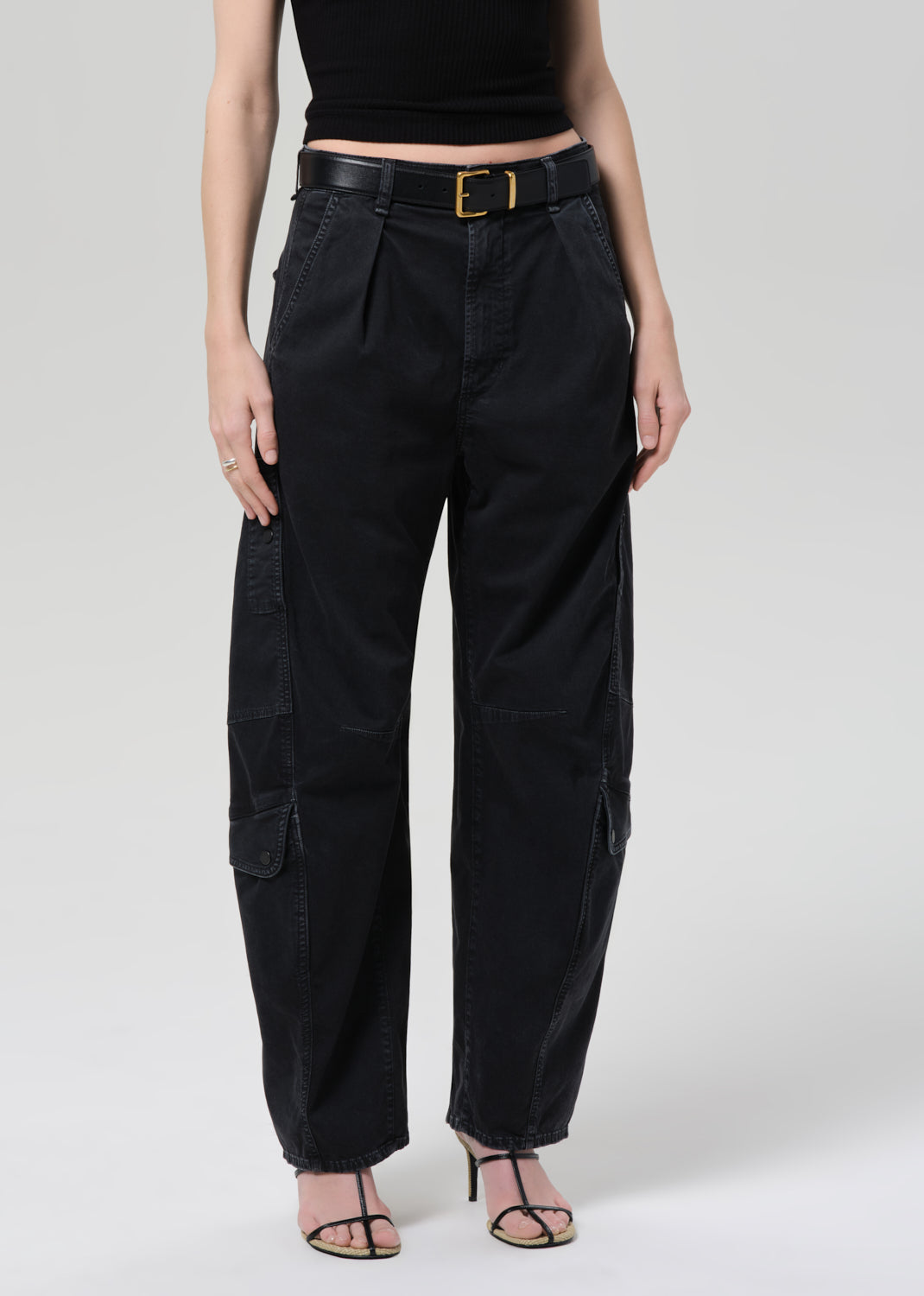 Person wearing a black tee and black cargo pants on a plain background