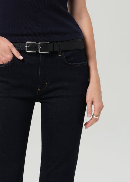 Person wearing a navy t-shirt and dark jeans on a plain background