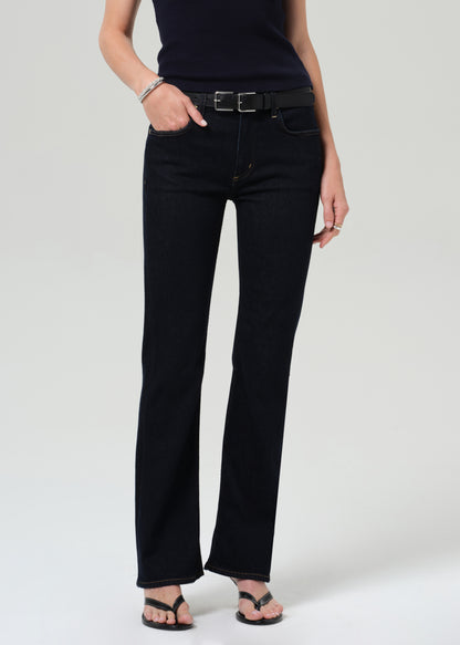 Person wearing a navy t-shirt and dark jeans on a plain background