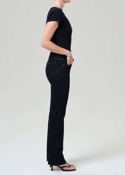 Person wearing a navy t-shirt and dark jeans on a plain background