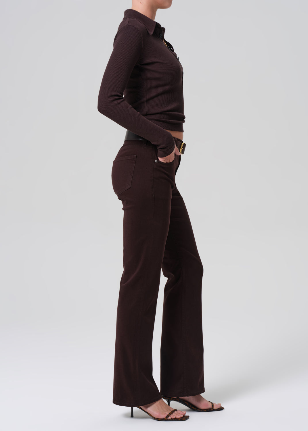 Person wearing a brown long-sleeve shirt and pants on a grey background