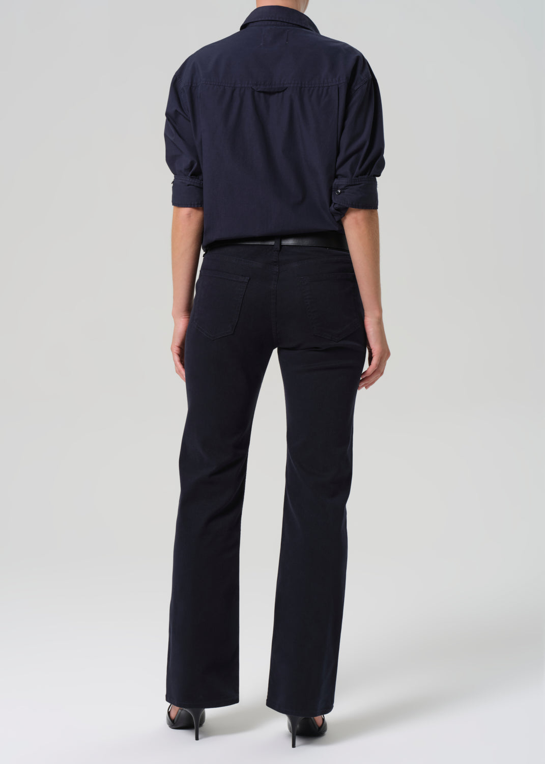 Person wearing a navy shirt and navy pants on a white background