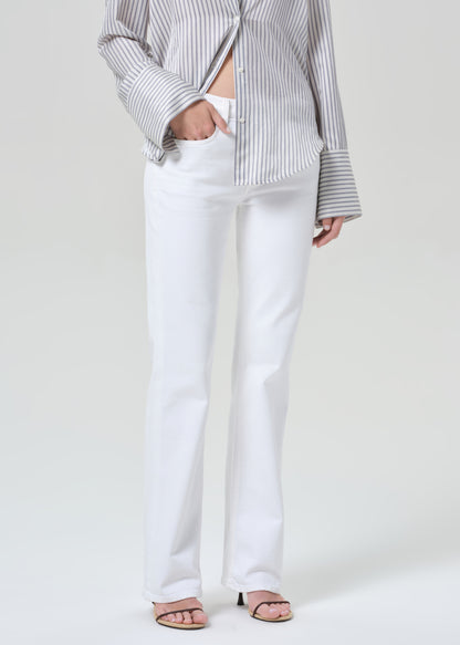 Person wearing a striped shirt and white jeans on a plain background