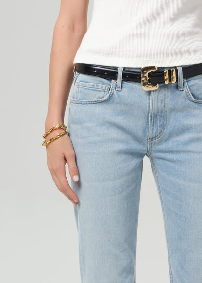 Light blue jeans with a black belt and gold buckle on a plain background