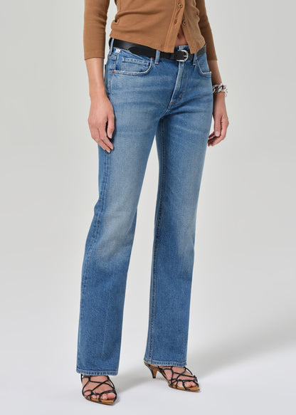 Person wearing blue jeans on a plain background