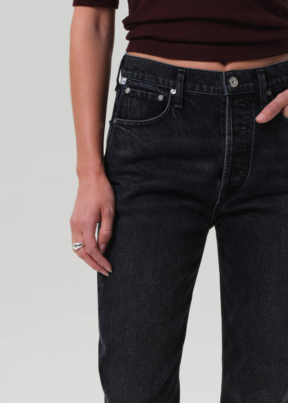 Person wearing black jeans on a plain background