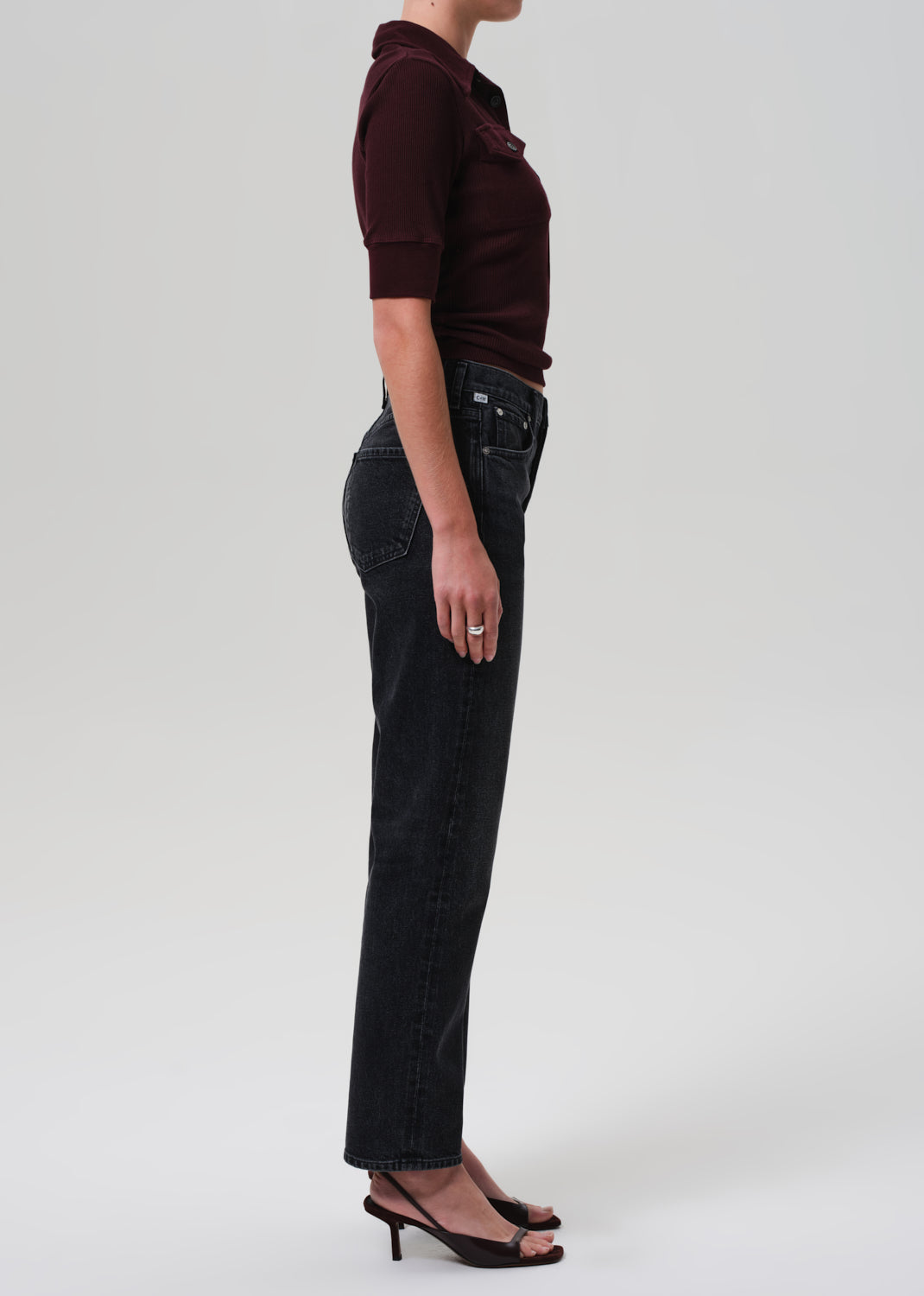 Person wearing a dark shirt and black pants on a white background