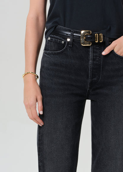 Person wearing a black t-shirt and black jeans on a grey background