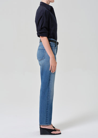 Person wearing blue jeans and a navy shirt on a grey background