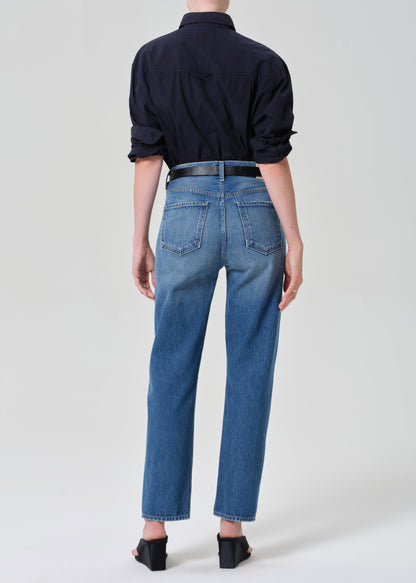 Person wearing blue jeans and a navy shirt on a grey background