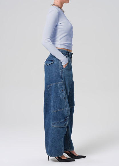 Person wearing blue jeans and a light blue top on a white background