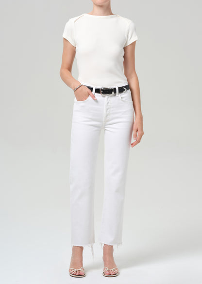 Person wearing a white t-shirt and white pants on a plain background