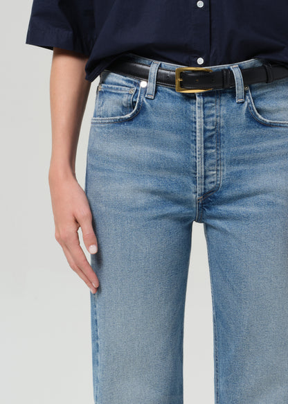 Person wearing blue jeans and a navy shirt on a plain background