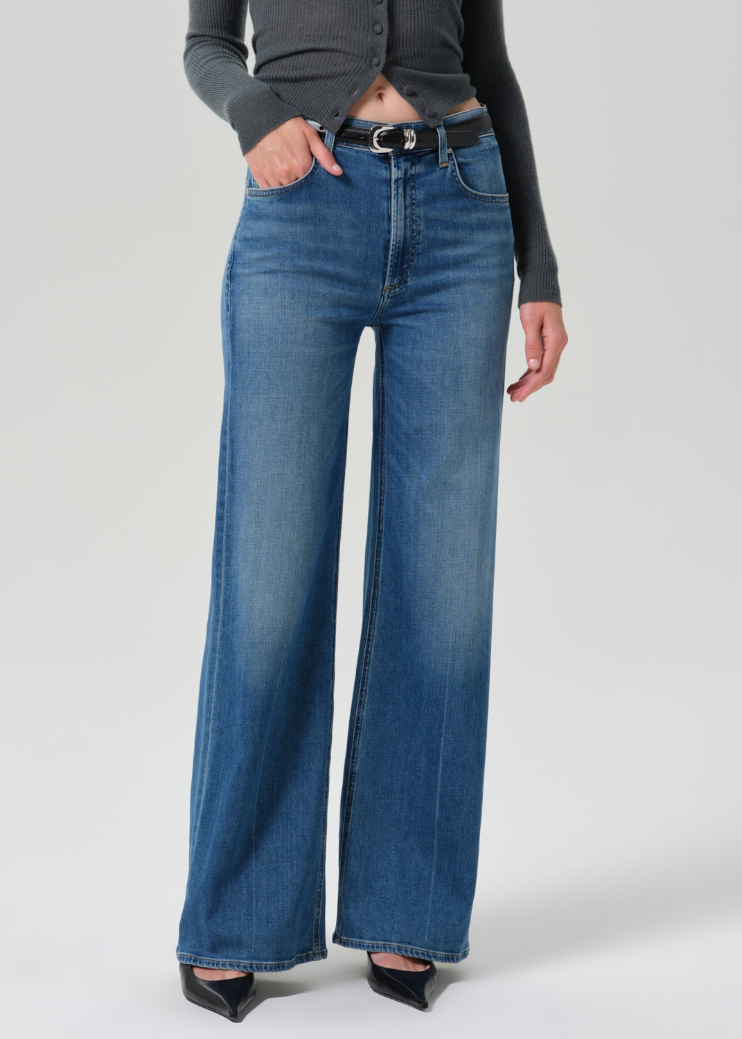 Close up of blue jeans on a grey background