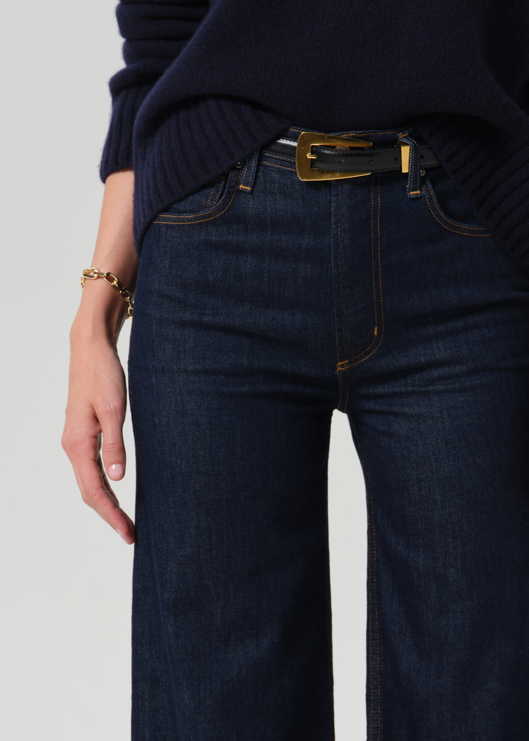 Close up of dark blue jeans on a grey background