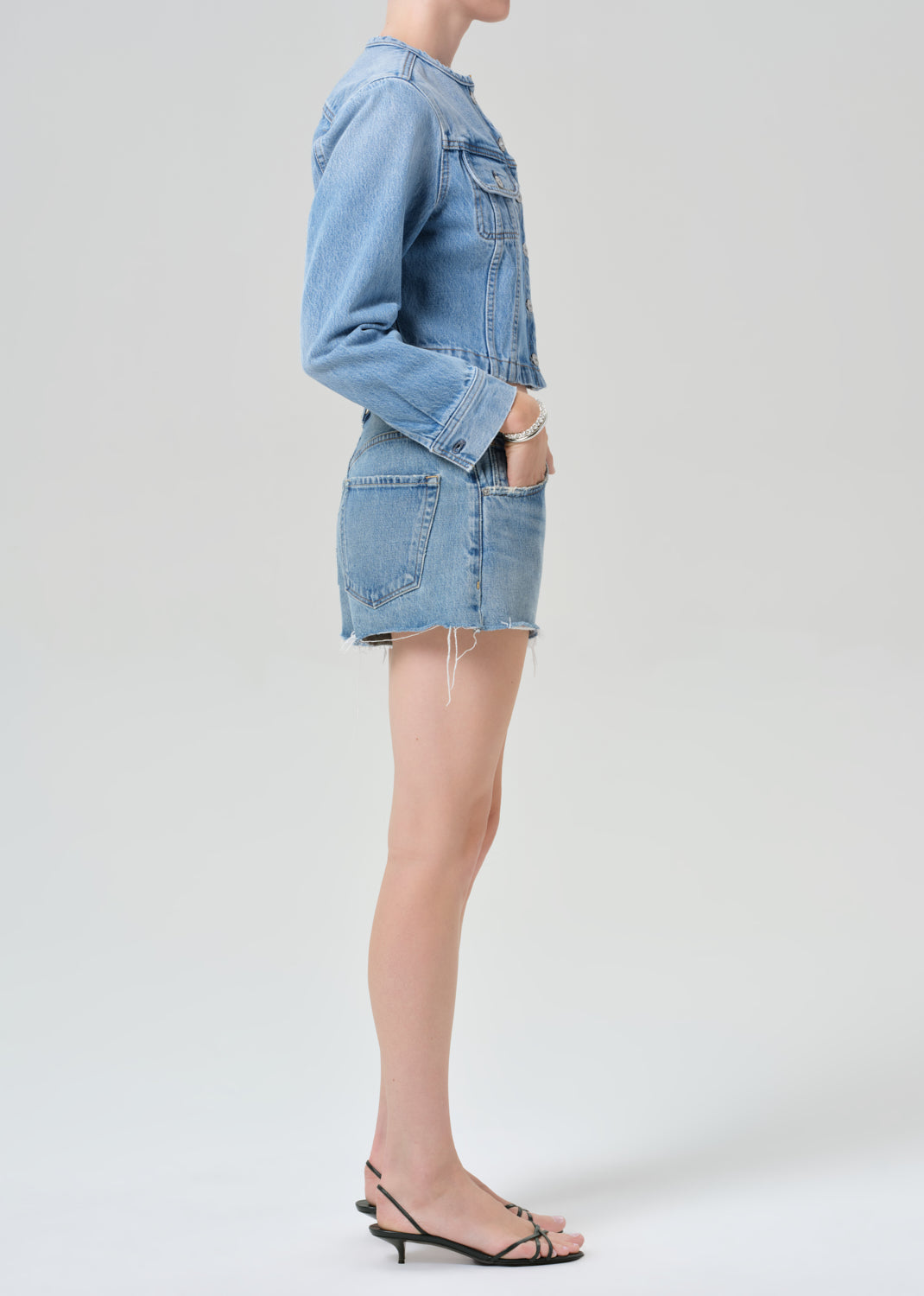 Person wearing a denim outfit on a plain background