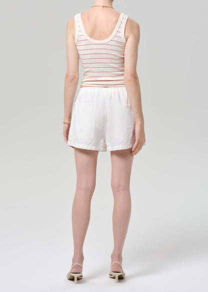 Person wearing a striped tank top and white shorts on a plain background
