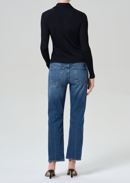 Person wearing a navy shirt and blue jeans on a grey background