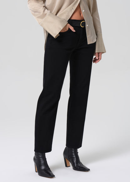 Person wearing black pants and black boots on a grey background