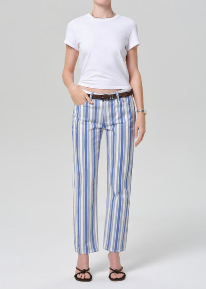 Person wearing a white t-shirt and blue striped pants on a light gray background