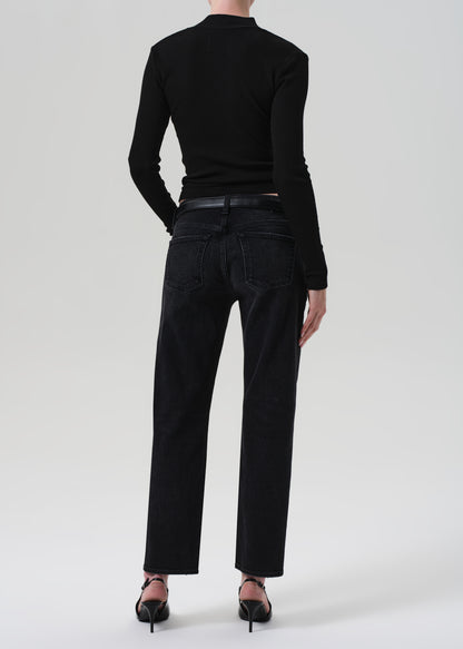 Person wearing a black henley and black jeans on a white background