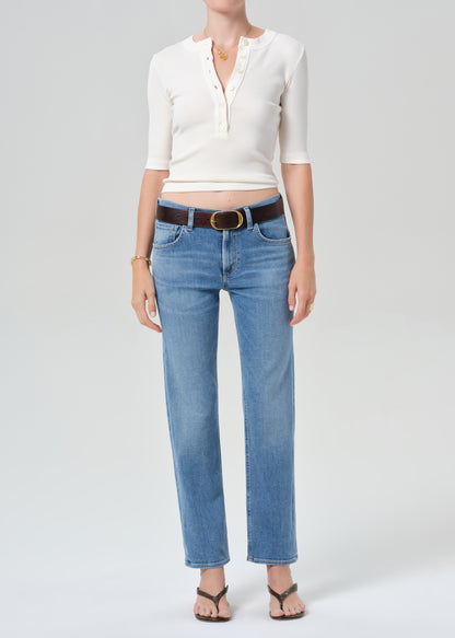 Person wearing a white top and blue jeans on a plain background