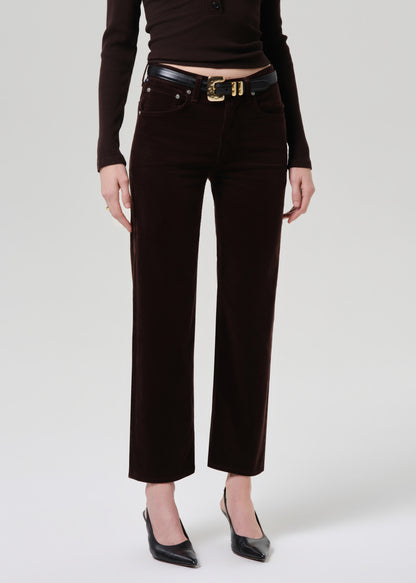 Person wearing black pants with a belt on a grey background