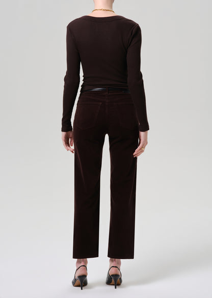 Person wearing a brown long-sleeve top and matching pants on a grey background