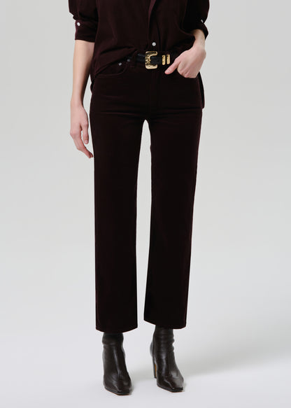Person wearing black pants with a gold belt on a grey background