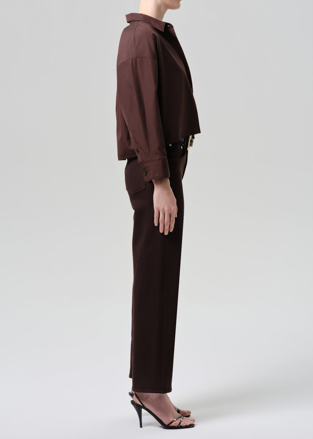 Person wearing a brown outfit on a grey background