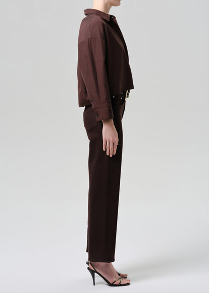 Person wearing a brown outfit on a grey background