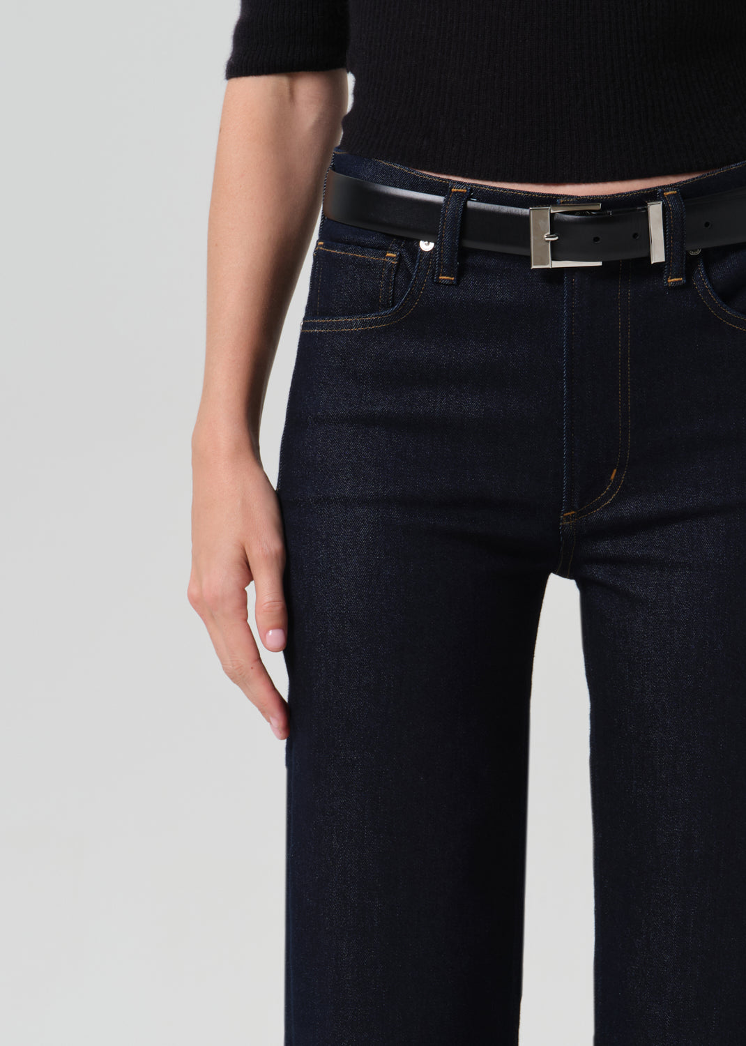 Close up of dark blue jeans on a grey background