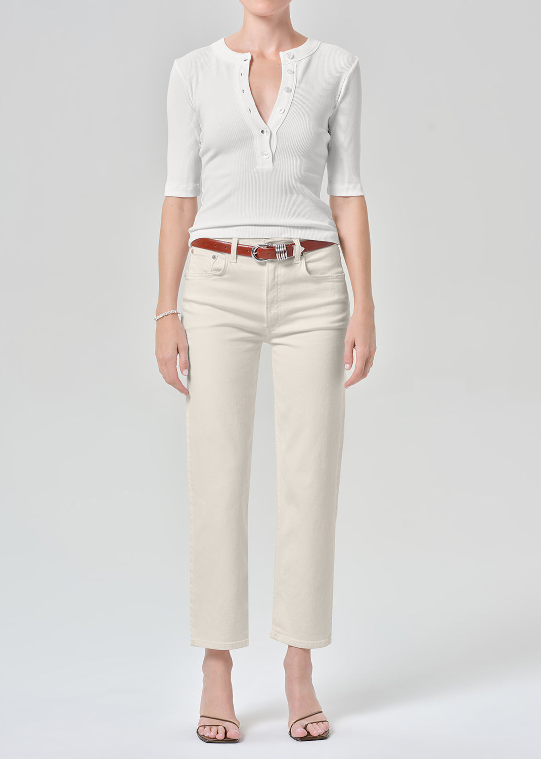 Persson wearing a white top with almond colored ankle jeans