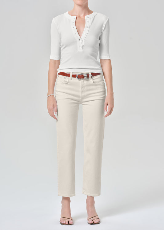 Persson wearing a white top with almond colored ankle jeans