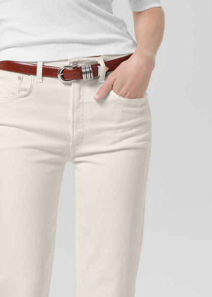 Persson wearing a white top with almond colored ankle jeans